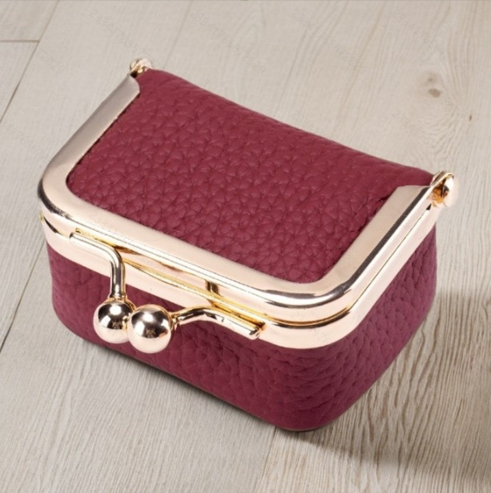 Genuine leather mini jewelry case in burgundy with gold-tone clasp, portable and compact for earrings, rings, and necklaces storage.