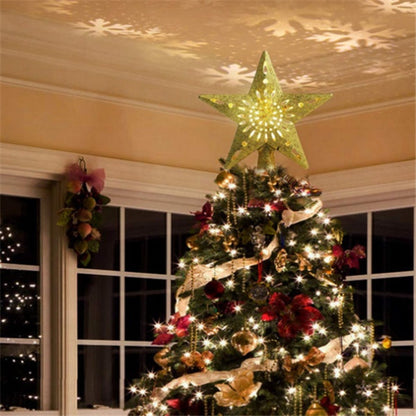 Christmas tree with glowing star-shaped LED projector light casting snowflake patterns on the ceiling