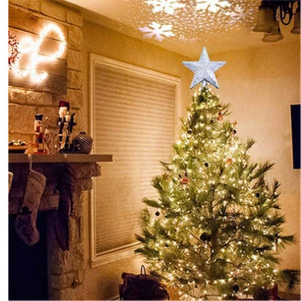Christmas tree with glowing star-shaped LED top light projecting snowflake patterns on ceiling